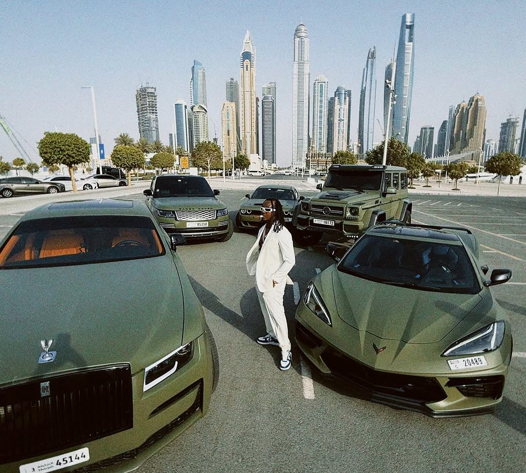 AB Marshall in Dubai, standing among his car collection with the Dubai Marina skyline behind him